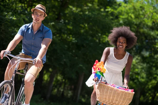 Mladí mnohonárodnostní pár má na kole jezdit v přírodě — Stock fotografie