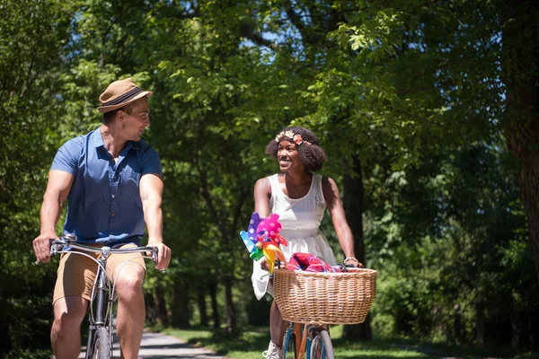 Joven pareja multiétnica teniendo un paseo en bicicleta en la naturaleza — Foto de Stock