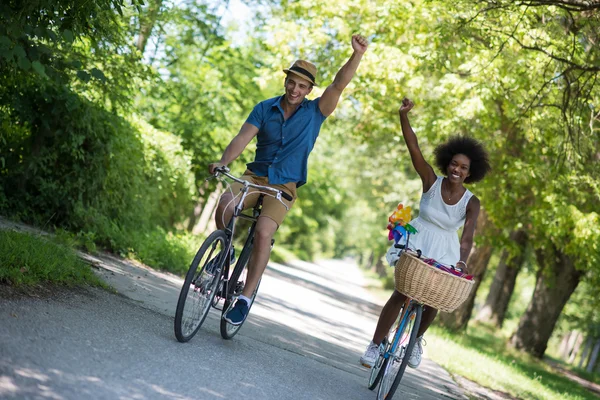 Νεαρό ζευγάρι πολυεθνική έχοντας ένα ποδήλατο βόλτα στη φύση — Φωτογραφία Αρχείου