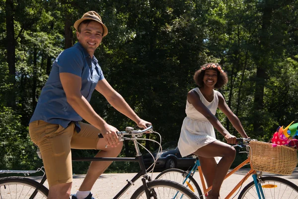 Jonge multi-etnisch paar met een fiets rijden in de natuur — Stockfoto