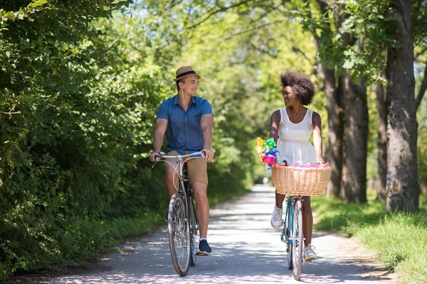 Joven pareja multiétnica teniendo un paseo en bicicleta en la naturaleza — Foto de Stock