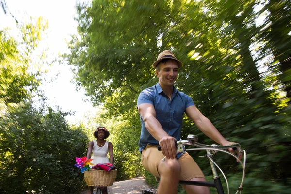 Young multiethnic couple having a bike ride in nature — Stock Photo, Image