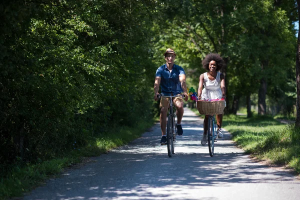 Jeune couple multiethnique faisant une balade à vélo dans la nature — Photo