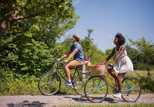 Joven pareja multiétnica teniendo un paseo en bicicleta en la naturaleza — Foto de Stock