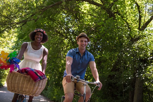 Jovem casal multiétnico ter um passeio de bicicleta na natureza — Fotografia de Stock