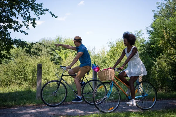 Jeune couple multiethnique faisant une balade à vélo dans la nature — Photo