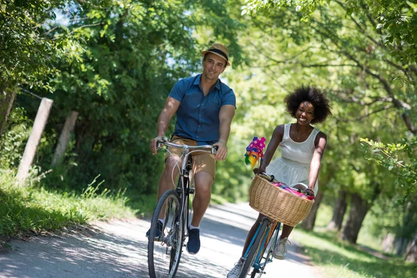自転車を持っている若い民族カップルが自然に乗る — ストック写真