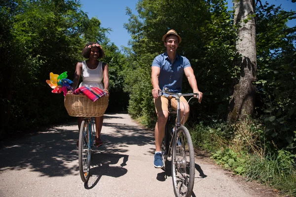 Молодая многонациональная пара, путешествующая на велосипеде по природе — стоковое фото
