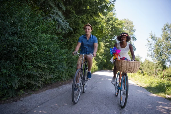 Young multiethnic couple having a bike ride in nature — Stock Photo, Image