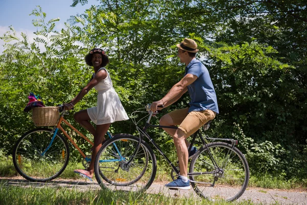 Jeune couple multiethnique faisant une balade à vélo dans la nature — Photo