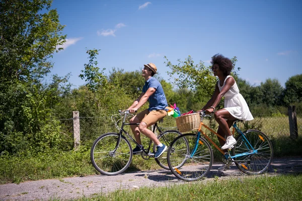 Joven pareja multiétnica teniendo un paseo en bicicleta en la naturaleza —  Fotos de Stock