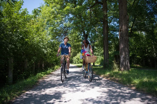 Jeune couple multiethnique faisant une balade à vélo dans la nature — Photo