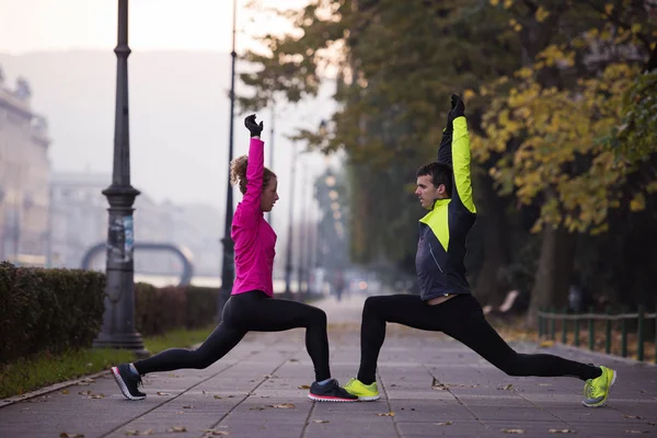 Couple warming up before jogging — Stock Photo, Image