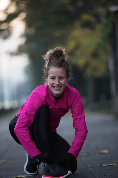 Vrouw die zich uitstrekt voordat ochtend joggen — Stockfoto