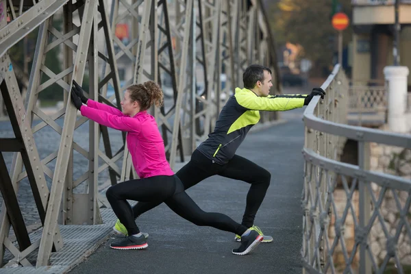 Couple warming up before jogging — Stock Photo, Image