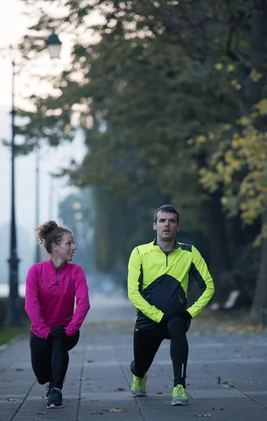 Couple warming up before jogging — Stock Photo, Image