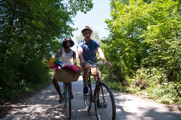 Jovem casal multiétnico ter um passeio de bicicleta na natureza — Fotografia de Stock