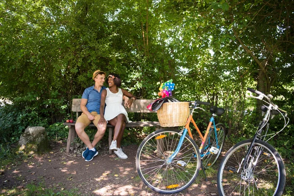 Jovem casal multiétnico ter um passeio de bicicleta na natureza — Fotografia de Stock