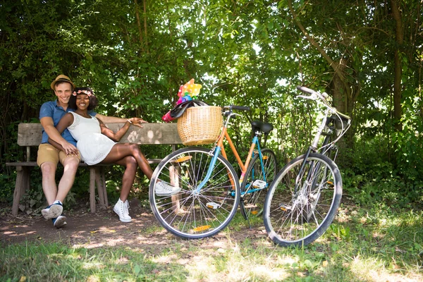 Jovem casal multiétnico ter um passeio de bicicleta na natureza — Fotografia de Stock