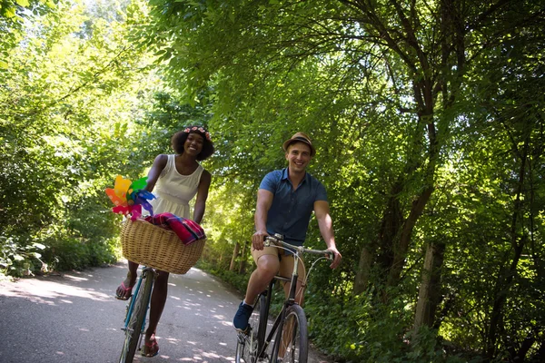 Jovem casal multiétnico ter um passeio de bicicleta na natureza — Fotografia de Stock