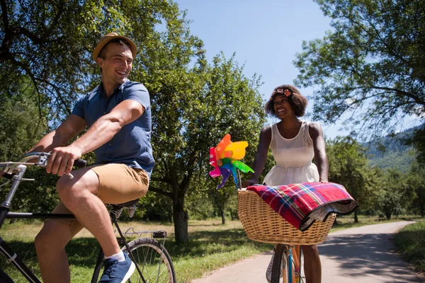 Joven pareja multiétnica teniendo un paseo en bicicleta en la naturaleza — Foto de Stock