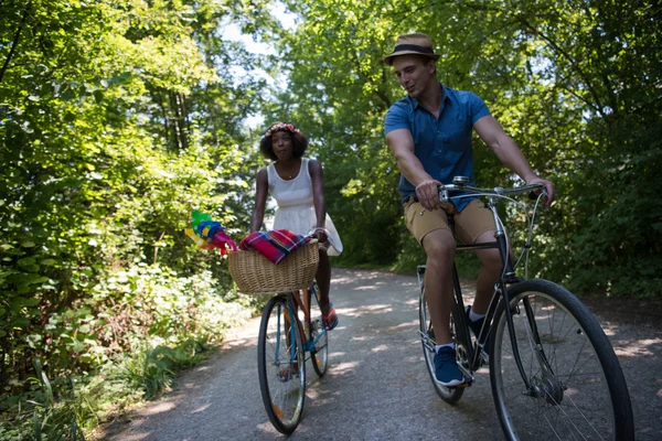 Young multiethnic couple having a bike ride in nature — Stock Photo, Image