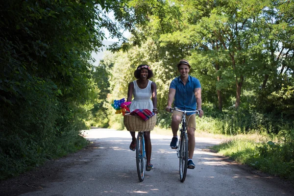 Jeune couple multiethnique faisant une balade à vélo dans la nature — Photo