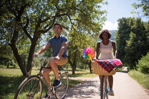 Jovem casal multiétnico ter um passeio de bicicleta na natureza — Fotografia de Stock
