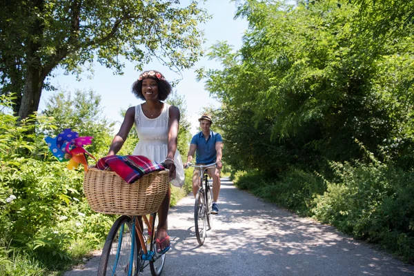 Jeune couple multiethnique faisant une balade à vélo dans la nature — Photo