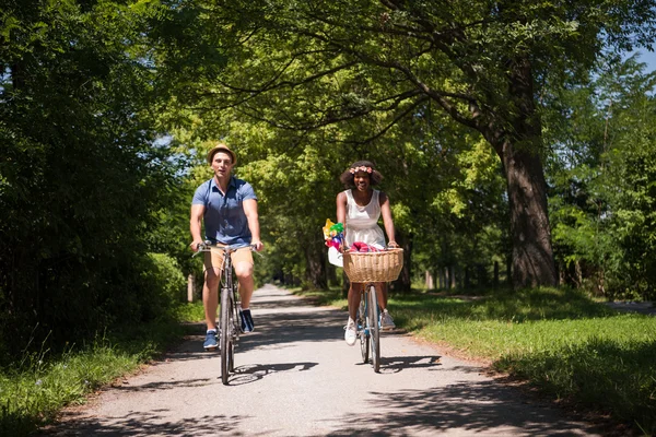 Joven pareja multiétnica teniendo un paseo en bicicleta en la naturaleza —  Fotos de Stock