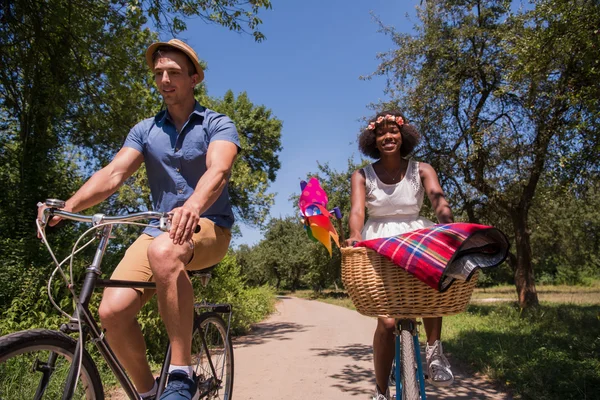 Joven pareja multiétnica teniendo un paseo en bicicleta en la naturaleza —  Fotos de Stock