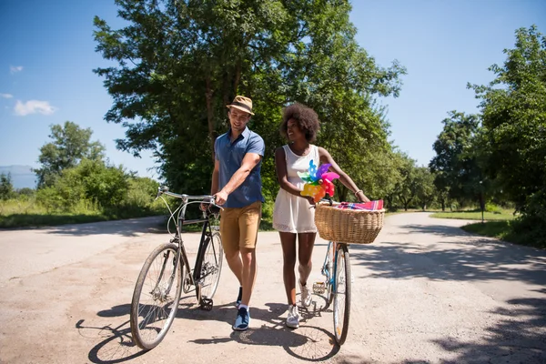 Mladí mnohonárodnostní pár má na kole jezdit v přírodě — Stock fotografie