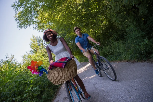 Jovem casal multiétnico ter um passeio de bicicleta na natureza — Fotografia de Stock