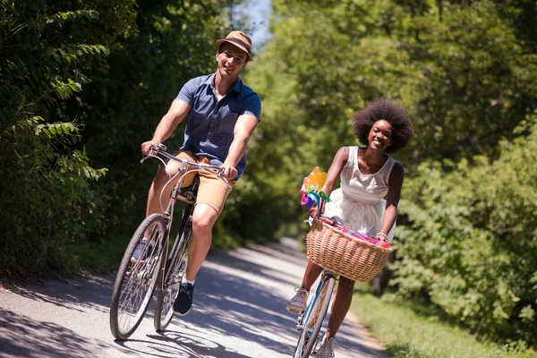 Joven pareja multiétnica teniendo un paseo en bicicleta en la naturaleza — Foto de Stock