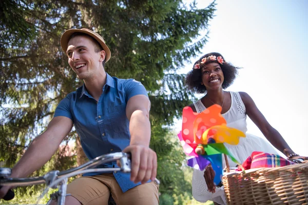 Jovem casal multiétnico ter um passeio de bicicleta na natureza — Fotografia de Stock