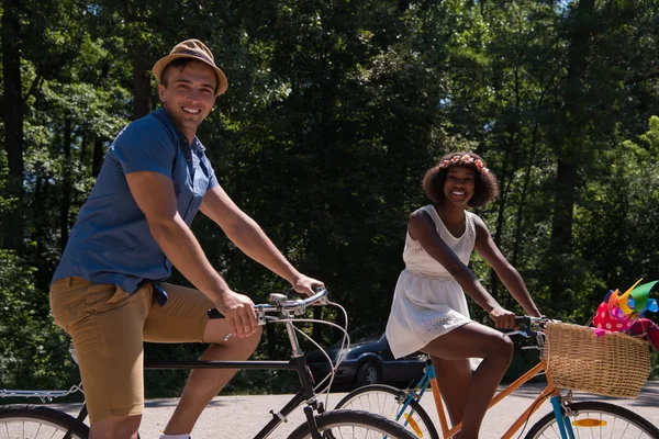 Jovem casal multiétnico ter um passeio de bicicleta na natureza — Fotografia de Stock