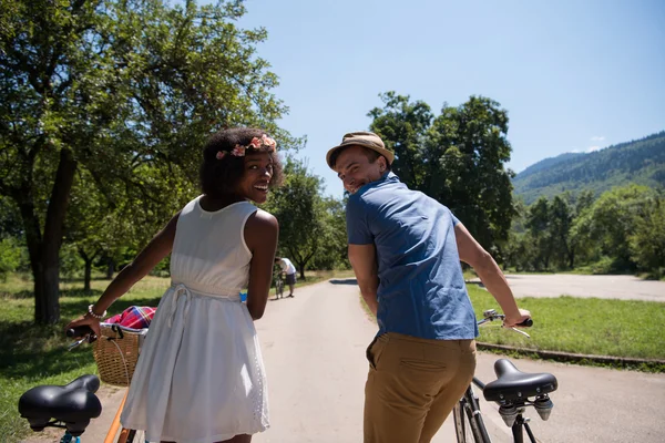 Jeune couple multiethnique faisant une balade à vélo dans la nature — Photo