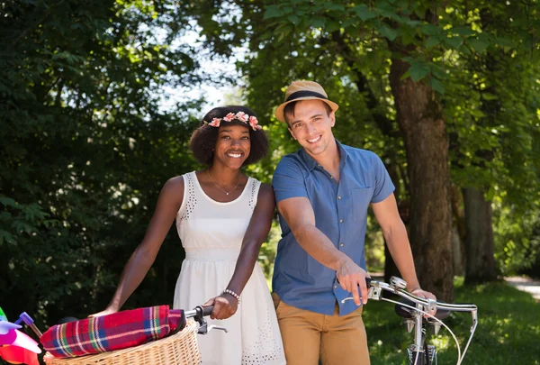Giovane coppia multietnica che fa un giro in bicicletta nella natura — Foto Stock