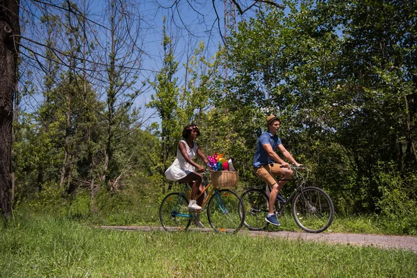 Unga multietniskt par att ha en cykel rida i naturen — Stockfoto