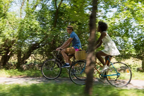 Jovem casal multiétnico ter um passeio de bicicleta na natureza — Fotografia de Stock