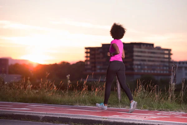 A young African American woman jogging outdoors — Stock Photo, Image