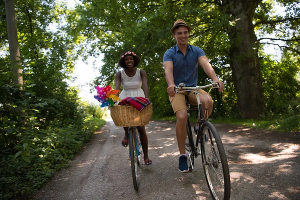 Jeune couple multiethnique faisant une balade à vélo dans la nature — Photo