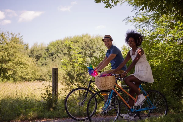 Joven pareja multiétnica teniendo un paseo en bicicleta en la naturaleza — Foto de Stock