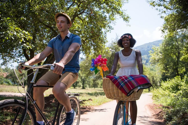 Giovane coppia multietnica che fa un giro in bicicletta nella natura — Foto Stock