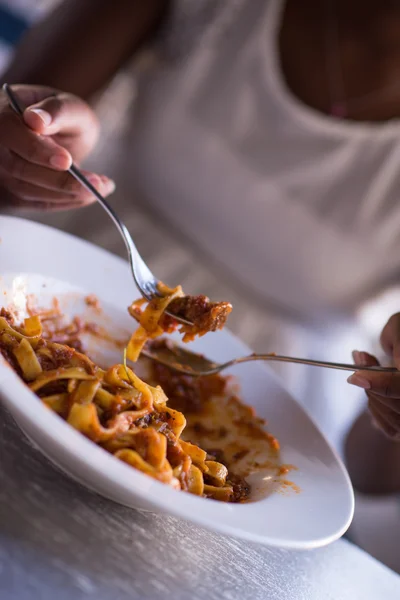 Seorang wanita muda Afrika-Amerika makan pasta — Stok Foto