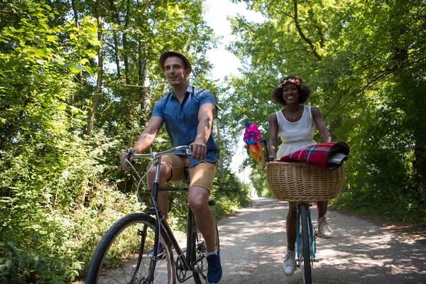 Jeune couple multiethnique faisant une balade à vélo dans la nature — Photo