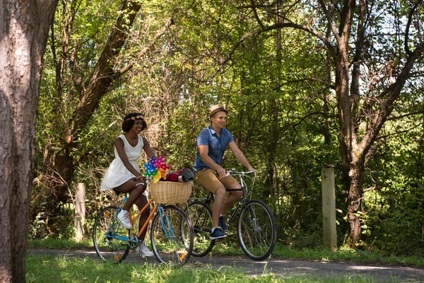 自転車を持っている若い民族カップルが自然に乗る — ストック写真
