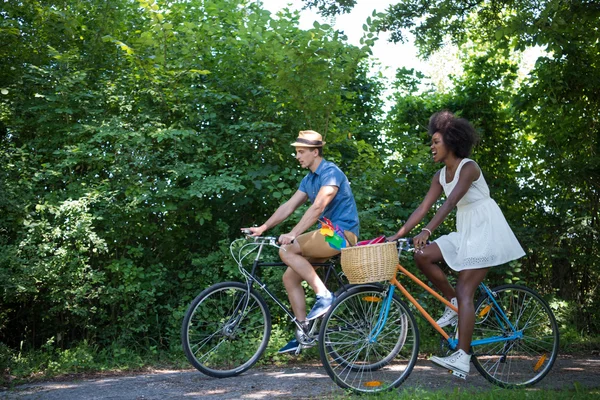 Jeune couple multiethnique faisant une balade à vélo dans la nature — Photo