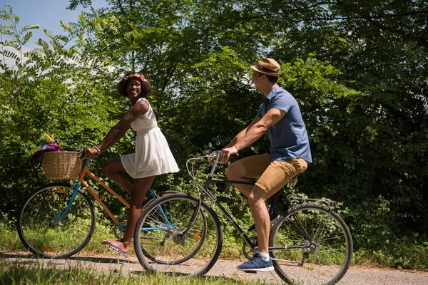 Jeune couple multiethnique faisant une balade à vélo dans la nature — Photo