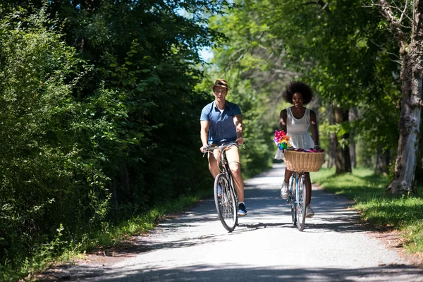 Unga multietniskt par att ha en cykel rida i naturen — Stockfoto